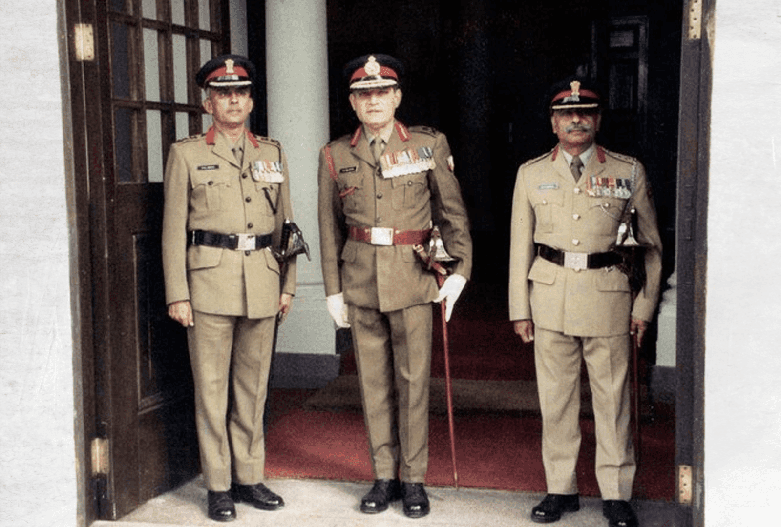 Lieutenant General Faridoon Bilimoria (center) standing in full ceremonial military uniform, flanked by two high-ranking officers.