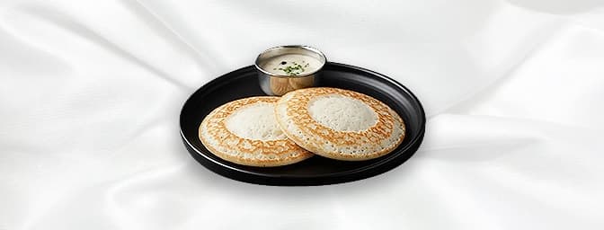 Appam — Appam is the soft pancake made from yeast fermented rice batter, with a soft spongy middle, which is laced with crisp