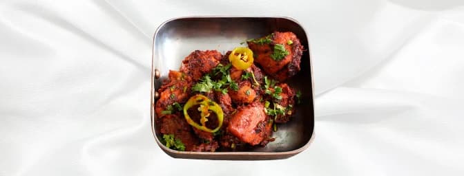 Chilli Chicken — Made from chicken breast slices, marinated in many spices and cooked with onion, tomato, capsicum, and green