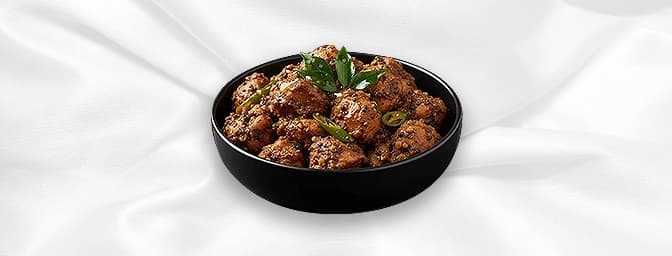 Kozhi ularthiyathu — Slow roasted tender chicken cubes with traditional Keralan aromatic spices, ginger, coconut slices and t