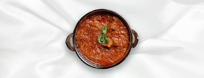 Lamb Rogan Josh — A lamb curry with a rich, flavorful sauce made from tomatoes, onions, and aromatic spices, GB Canteen Buckh