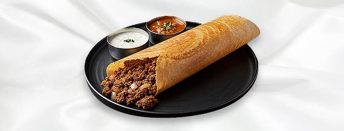 Nair masala Dosa — A rice and lentil pancake thinly spread with tangy red chutney and melted butter filled with a mixture of 