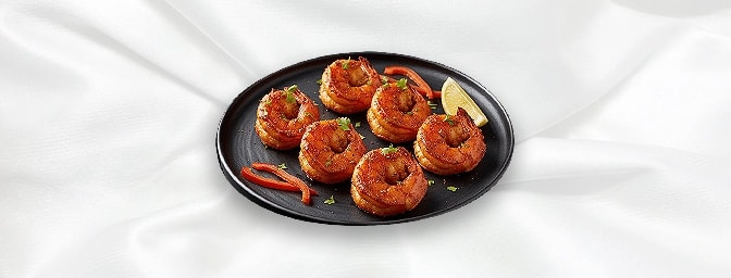 Jingha Ananash — King prawns briskly stir-fried in a light curry sauce, flavoured with pineapple chunks, served in half a pin