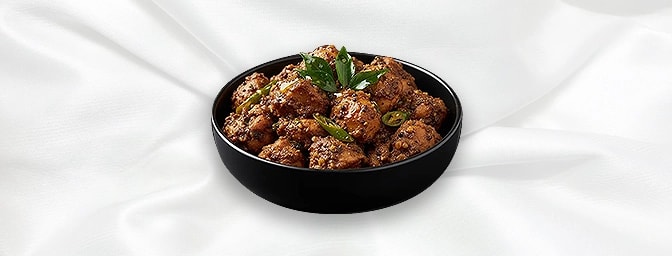 Kozhi ularthiyathu — Slow roasted tender chicken cubes with traditional Keralan aromatic spices, ginger, coconut slices and t