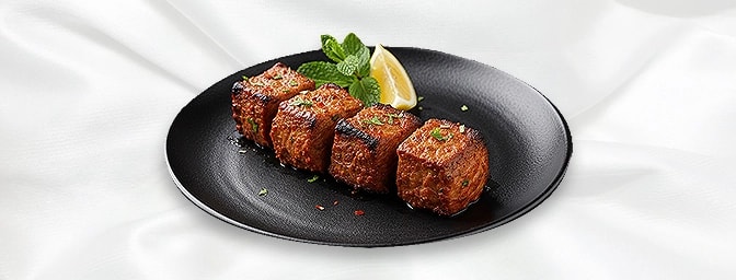 Bahar-e-Lamb Tikka — Marinated lamb tikka cubes, skewered with green pepper, tomato and onion, grilled in the tandoor, GB Can