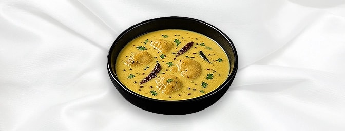 Punjabi Kadi — Homestyle tempered yoghurt curry laced with chickpea flour, turmeric, spices and simmered with vegetable dumpl