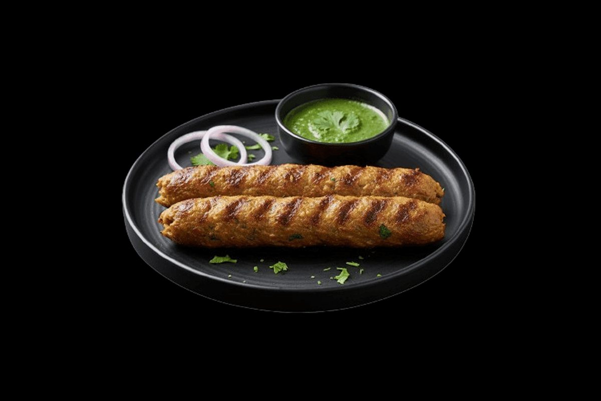 Lamb Sheek Kebab — Tender lamb minced with onion, fresh garlic, ginger, coriander leaves, and other fresh herbs. Skewered and