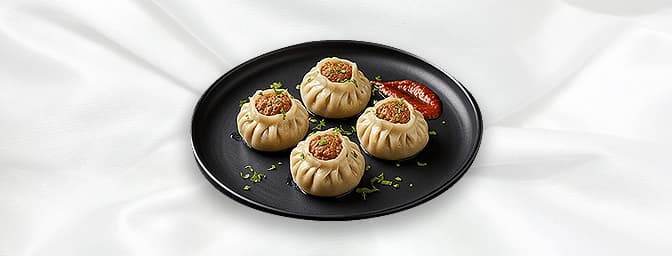 Vegetable Momo — Steam / Chilli Traditional Nepalese dumplings , either delicately steamed with house chutney or wok tossed w