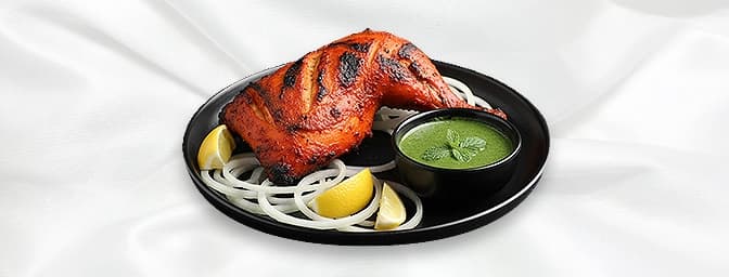 Tandoori Chicken — Half of spring chicken marinated in a mix of strained yogurt, ginger, garlic, lemon juice, spices, and sea