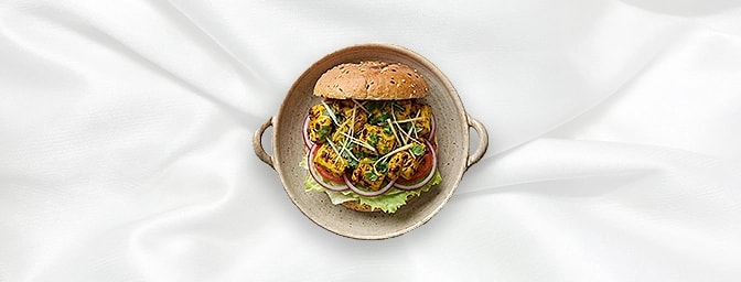 Chicken Tikka Burger — A succulent, tandoor-grilled chicken tikka breast takes center stage in this vibrant burger. Accompani