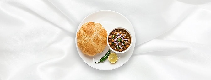 Chole Bhature — Succumb to tradition with our fluffy, golden deep-fried bread, served alongside a deeply spiced, aromatic chi