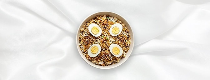 Egg Biryani — Savor the ultimate comfort with our Egg Biryani, where fragrant basmati rice is slow-steamed in a sealed pot wi