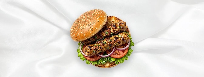 Lamb Seekh Burger — Elevate your burger game with delicately seasoned minced lamb, grilled to juicy perfection and tucked int