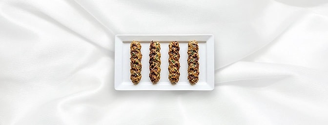 Malmali Seekh Kebab — Refined and regal. These delicate skewers of minced lamb are seasoned with a sophisticated blend of pal