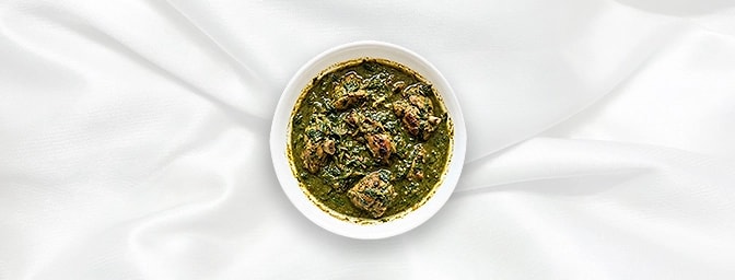 Palak Chicken — Indulge in tender, succulent chicken pieces simmered in a velvety blanket of farm-fresh spinach. This sophist