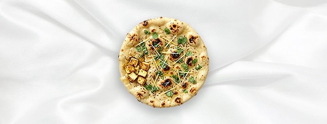 Paneer Kulcha — Indulge in sophistication with our leavened bread stuffed with spiced, crumbled cottage cheese. Each bite off