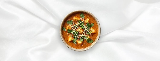 Paneer Makhni - Taster — The perfect gourmet snack. This taster portion features velvety cubes of paneer bathed in a mild, lu