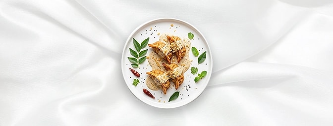 Veggie Afghani Momos — Experience pure indulgence with our vegetable dumplings, deep-fried and enveloped in a velvety, mild c