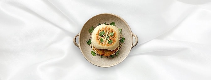 Bun Tikki — A sophisticated twist on a classic snack featuring a delicate patty of mashed potatoes and green peas. Served in
