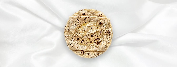 Butter Roomali Roti — An ultra-thin, handkerchief-soft flatbread baked on an upturned tawa and glazed with luscious butter. I