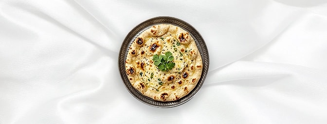 Cheese naan — The ultimate comfort food. This leavened bread is stuffed with a decadent layer of melted cheese, offering a wa