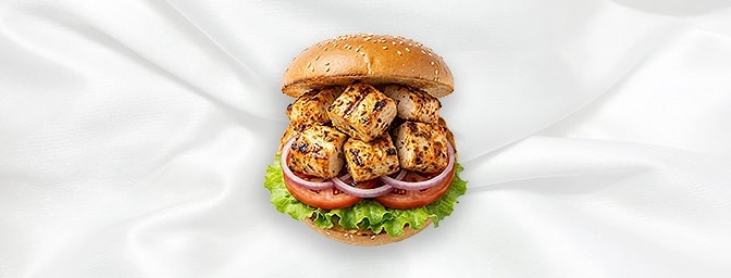 Chicken Malai Burger — Indulge in luxury with a tender chicken breast marinated in aromatic cardamom, mace, and soft cheese.