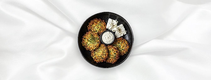 Mucver V — Pan Fried Patties Of Grated Courgettes, Onions, Carrots, Dill And Parsley. Served With Feta Cheese And Garlic Sauc