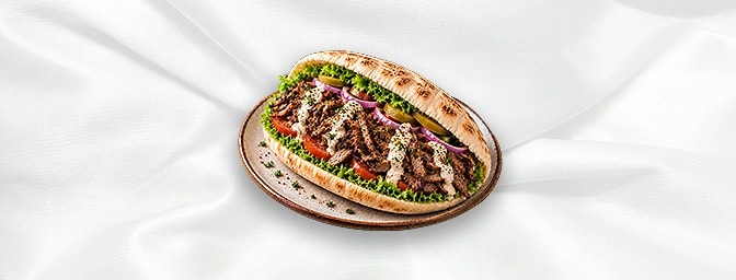 Lamb Shawarma Sandwiches — Thinly sliced marinated lamb cooked on a vertical rotisserie and served in pita bread or over rice