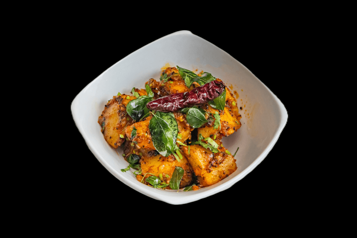 Bombay Potatoes — A spiced potato dish cooked with mustard seeds, cumin, and turmeric, offering a rich, savory, and slightly